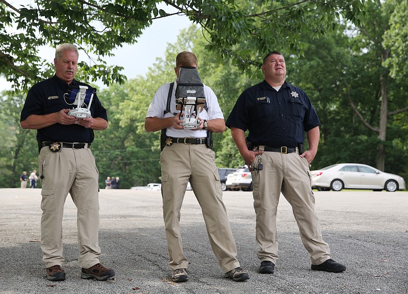 Hamilton County Sheriff's Office Detective Shane Forgey watches video of the unmanned aerial surveillance system while Detective Marty Dunn navigates and Detective Richard Whaley watches it approach the shore Friday, May 19, 2017, at Chester Frost Park in Hixson, Tenn. The cost to fly manned aviation in public safety is estimated around $350 per hour, while using unmanned aerial surveillance systems, or drones, to support operations are estimated to cost just below $25 per hour. 