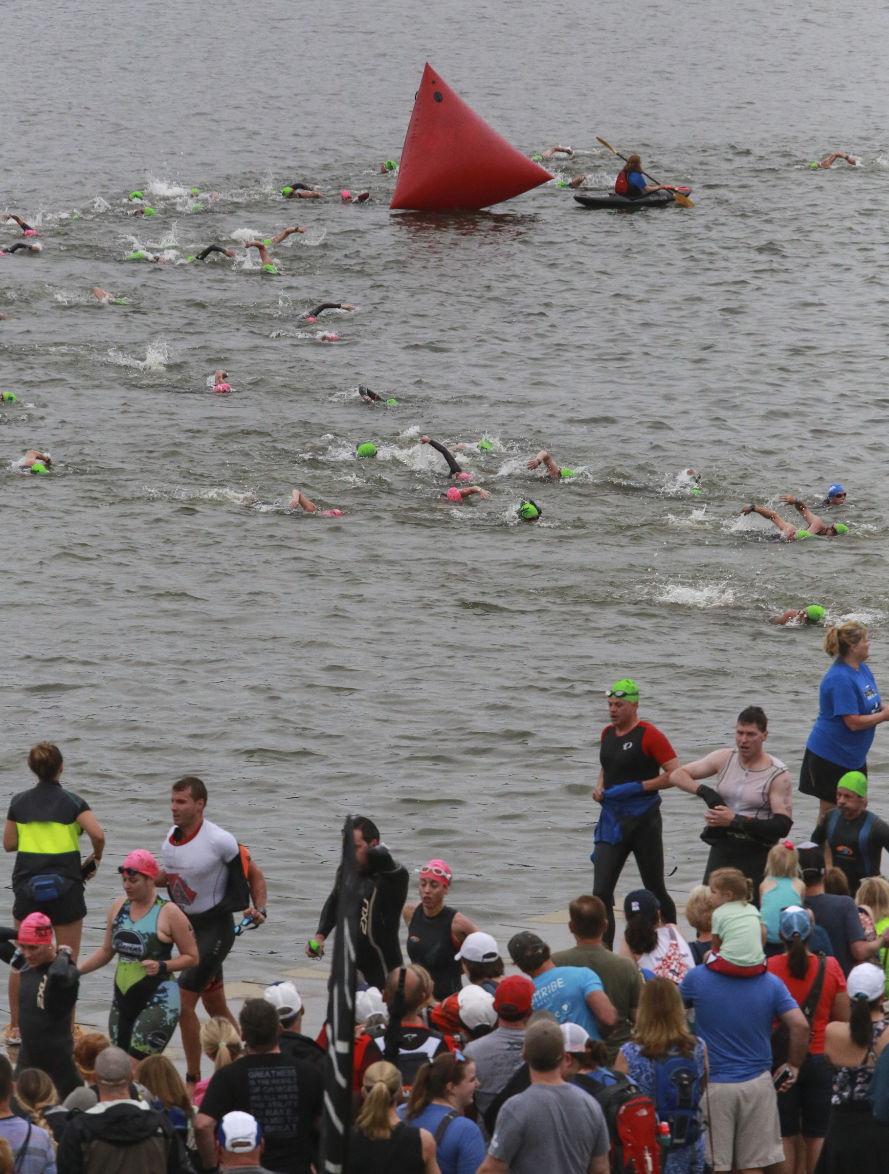 Age group athletes transition from the swim to the bike portion of the race during the Sunbelt Bakery IRONMAN 70.3 Chattanooga triathlon presented by McKee A Family Bakery in downtown Chattanooga on Sunday, May 21, 2017. Photo by Dan Henry | DanHenryPhotography.com