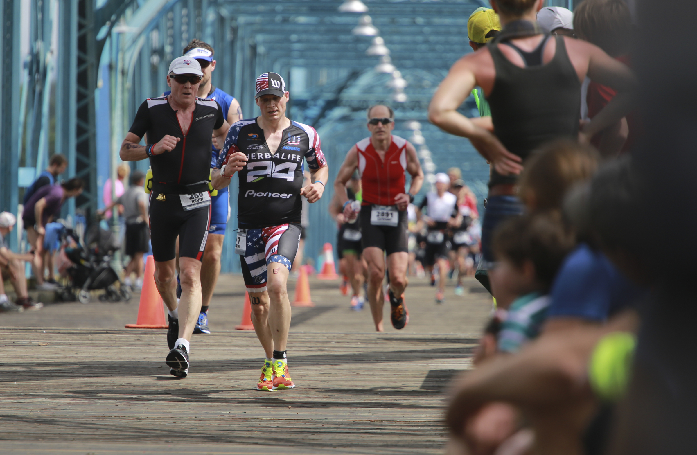 Age group athletes make their way over the Walnut Street Bridge during the last leg of the Sunbelt Bakery IRONMAN 70.3 Chattanooga triathlon presented by McKee A Family Bakery in downtown Chattanooga on Sunday, May 21, 2017. Photo by Dan Henry | DanHenryPhotography.com