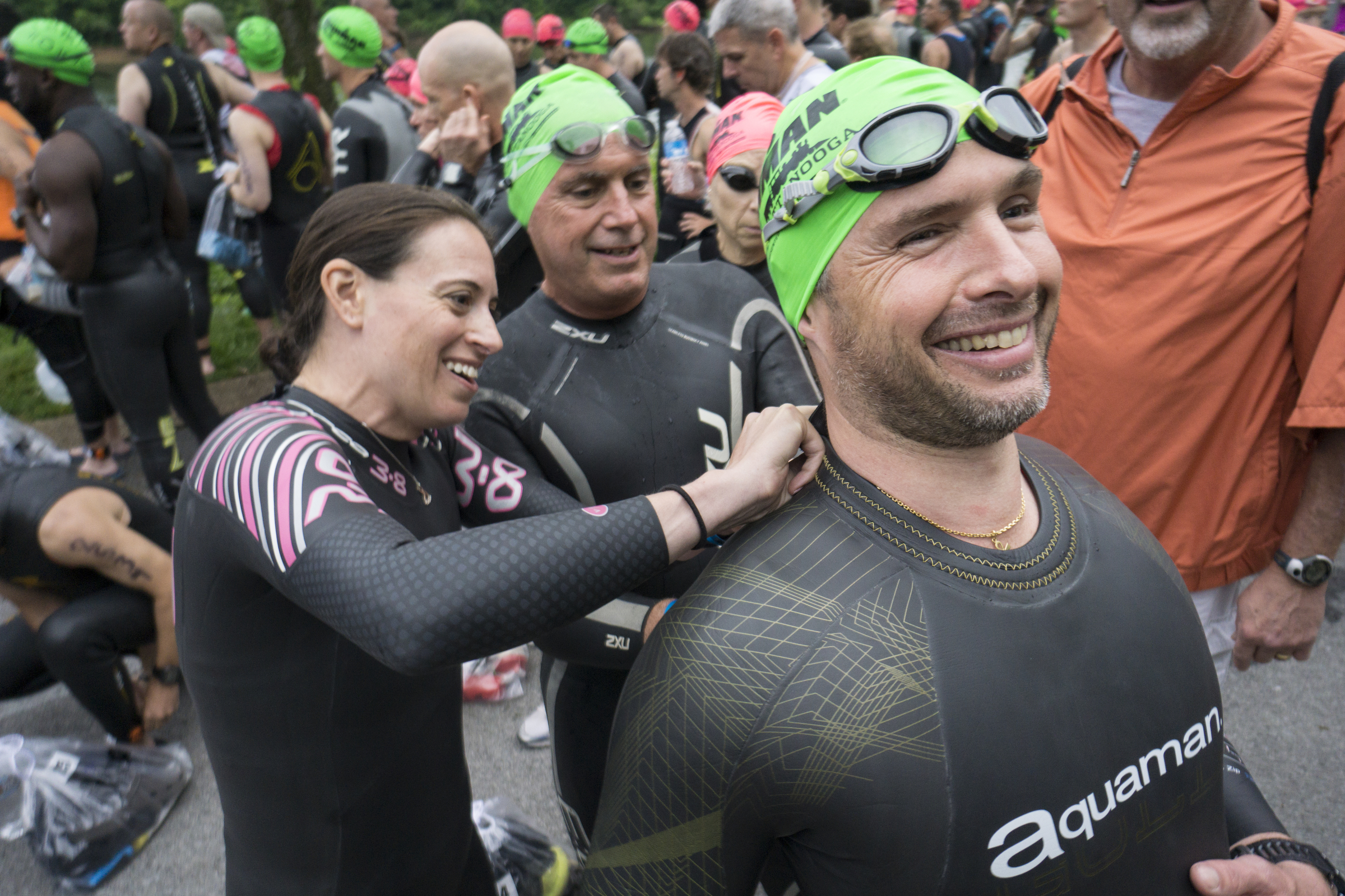 Alexandre Simmler, right, has help from Kimberly Lerman and Jeffrey Pack to zip up his wetsuit as he and other age group athletes line up for the swim before competing in the Sunbelt Bakery IRONMAN 70.3 Chattanooga triathlon presented by McKee A Family Bakery in downtown Chattanooga on Sunday, May 21, 2017. Photo by Dan Henry | DanHenryPhotography.com