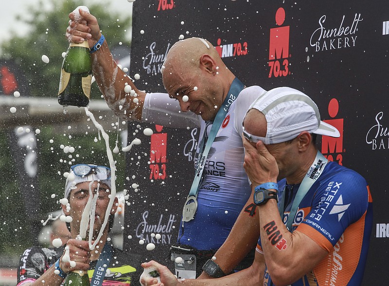 Matthew Russell, first place, Adam Otstot, second place, and Antoine Jolicoeur Desroches celebrate on the awards podium after Sunday's Sunbelt Bakery Ironman 70.3 half triathlon in Chattanooga.