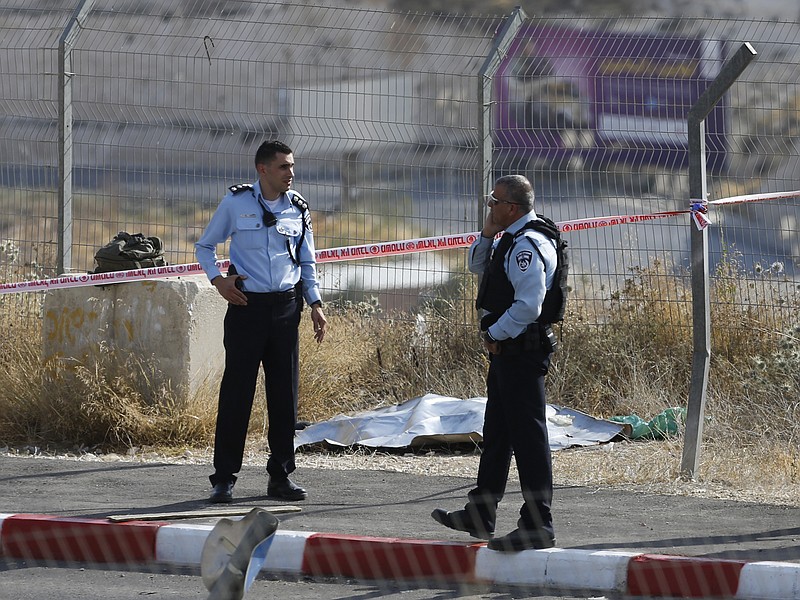 
              Israeli police stand by the body of a Palestinian who was shot and killed after he attempted to stab an Israeli soldier at a checkpoint north of the West Bank city of Bethlehem , Monday, May 22, 2017. (AP Photo/Nasser Shiyoukhi).
            