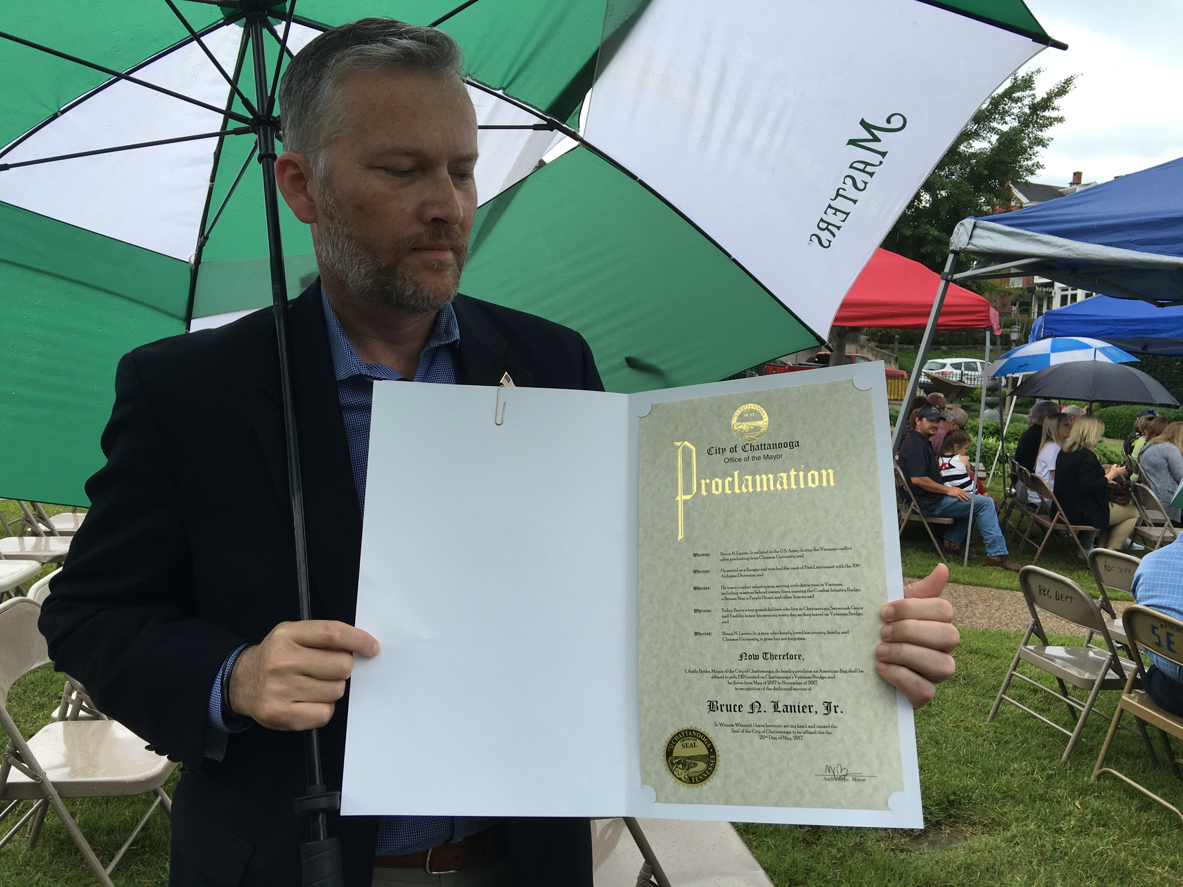 David Steele displays the proclamation honoring his father-in-law, Bruce N. Lanier Jr., with a flag on Veterans Bridge. Lanier, a Clemson graduate, served as a decorated combat infantryman in the Vietnam War.
