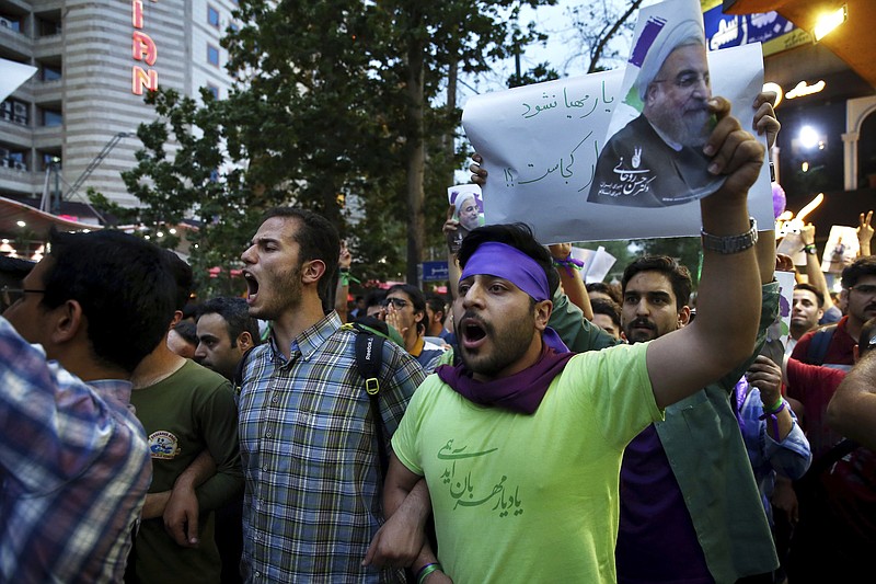 
              Supporters of Iranian President Hassan Rouhani celebrate after he won the presidential election in Tehran, Iran, Saturday, May 20, 2017. Tens of thousands of supporters of President Hassan Rouhani have poured into the streets of Tehran as night falls to celebrate the incumbent's re-election. (AP Photo/Ebrahim Noroozi)
            