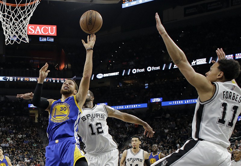 Golden State Warriors guard Stephen Curry (30) goes up for a shot as San Antonio Spurs' LaMarcus Aldridge (12) and Bryn Forbes (11) defend during the second half in Game 4 of the NBA basketball Western Conference finals, Monday, May 22, 2017, in San Antonio. (AP Photo/Eric Gay)