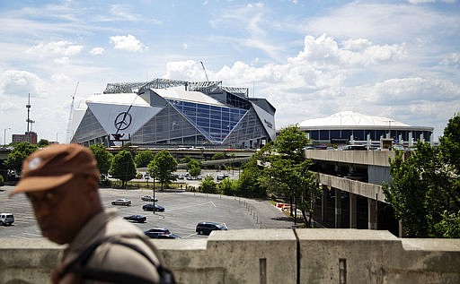 Mercedes-Benz Stadium, the new stadium for the Atlanta Falcons NFL football team, sits under construction at left next to the team's current stadium, the Georgia Dome, in Atlanta, Wednesday, May 17, 2017. Several high-profile failures have plagued Atlanta's reputation on a national stage over the years: transportation woes during the 1996 Olympics, unpreparedness for ice and snow storms, a recent highway collapse and subsequent shutdown from a fire. Now, the city's new $1.5 billion stadium, touted as a state-of-the-art facility that can help transform downtown, is facing construction setbacks with its key feature, a retractable roof that will open and close like a camera lens. (AP Photo/David Goldman)