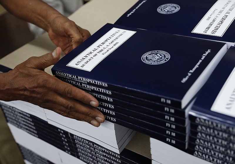 A Government Publishing Office employee stacks copies of "Analytical Perspectives Budget of the U.S. Government Fiscal Year 2018" onto a pallet.