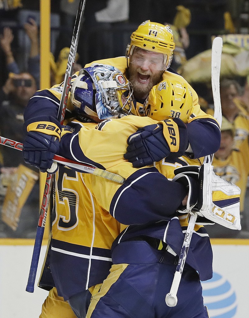
              Nashville Predators defenseman Mattias Ekholm (14), of Sweden, jumps on goalie Pekka Rinne (35), of Finland, and left wing Viktor Arvidsson (38), of Sweden, after the Predators beat the Anaheim Ducks to win Game 6 of the Western Conference final in the NHL hockey Stanley Cup playoffs Monday, May 22, 2017, in Nashville, Tenn. The Predators won 6-3 to win the series 4-2 and advance to the Stanley Cup Finals. (AP Photo/Mark Humphrey)
            