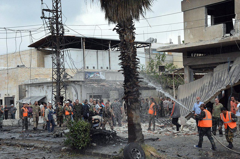 
              In this photo released by the Syrian official news agency SANA, Syrian security forces and firefighters gather at the scene of an explosion, in the central city of Homs, Syria, Tuesday, May 23, 2017. Syrian state TV reported that an explosion in the central city of Homs has killed several people and that government forces "destroyed" a truck bomb near the Damascus airport. (SANA via AP)
            