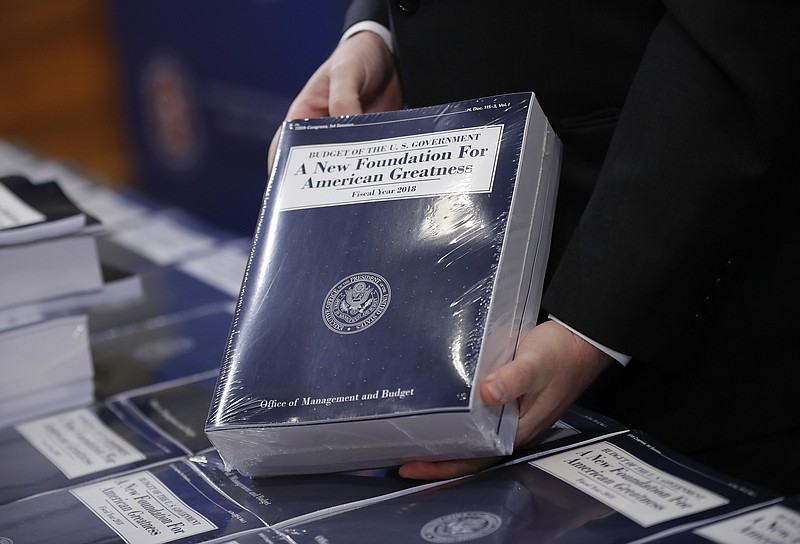 
              Eric Ueland, Republican staff director, Senate Budget Committee holds a copy of President Donald Trump's fiscal 2018 federal budget, before distributing them to congressional staffers on Capitol Hill in Washington, Tuesday, May 23, 2017. (AP Photo/Pablo Martinez Monsivais)
            