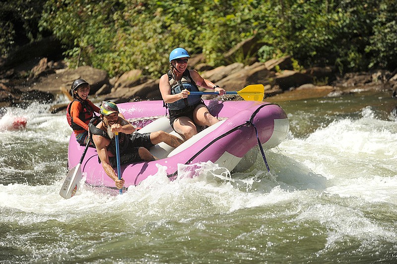 Shawn Malone's son River, left, guides during a rafting trip on the Ocoee River with his parents Shawn and Dana.