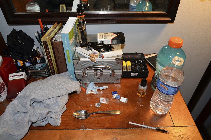 
              This Sunday, May 21, 2017, photo provided by the Chester County District Attorney's Office in West Chester, Pa., shows opioid drug packets, a syringe and other belongings found by law enforcement personnel in an addiction counselor's bedroom at the Freedom Ridge Recovery Lodge, a suburban Philadelphia halfway house in West Brandywine Township, Pa. Two men working as addiction counselors at the halfway house died of opioid overdoses inside the facility and were found by residents on Sunday, authorities announced Wednesday, May 24, 2017. (Chester County District Attorney's Office via AP)
            