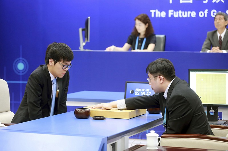 
              Chinese Go player Ke Jie, left, looks at the board as a person makes a move on behalf of Google's artificial intelligence program, AlphaGo, during a game of Go at the Future of Go Summit in Wuzhen in eastern China's Zhejiang Province, Tuesday, May 23, 2017. A computer that plays go has started a match against China's No. 1 player in a test of whether artificial intelligence can master one of the last games that machines have yet to dominate. (Chinatopix via AP)
            