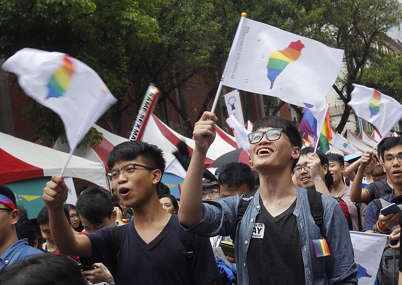 
              Same-sex marriage supporters wave rainbow Taiwan flags after the Constitutional Court ruled in favor of same-sex marriage outside the Legislative Yuan in Taipei, Taiwan, Wednesday, May 24, 2017. Taiwan's Constitutional Court ruled in favor of same-sex marriage on Wednesday, making the island the first place in Asia to recognize gay unions. (AP Photo/Chiang Ying-ying)
            