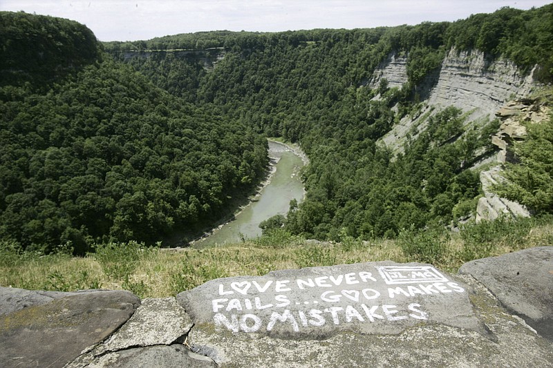 
              FILE - In this June 21, 2006, file photo, a message is seen painted on a rock wall overlooking Letchworth State Park in Castile, N.Y. A dog stuck about half-way down a 400-foot cliff in the park was rescued on May 22, 2017, by a police officer who had to use ropes to reach the stranded canine. (AP Photo/David Duprey, File)
            