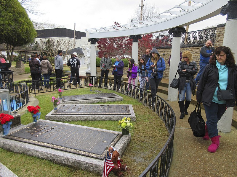 
              FILE - In this March 13, 2017, file photo, people walk through the Meditation Garden at Graceland in Memphis, Tenn., where Elvis Presley is buried along with his parents, grandmother and a memorial gravestone for his stillborn twin brother. Every year around the anniversary of the crooner's death, Presley's fans flock to Graceland, the Memphis tourist attraction focused on his music, movies and life. This year, Elvis Week takes place Aug. 11-19, marking the 40th anniversary of his passing. (AP Photo/Beth J. Harpaz, File)
            