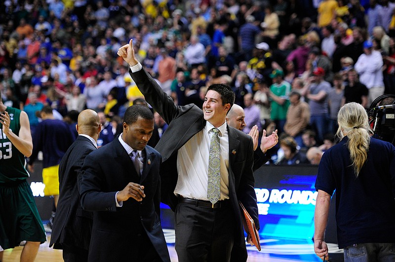 Aaron Fuss, with arm raised, has joined the UTC men's basketball staff.