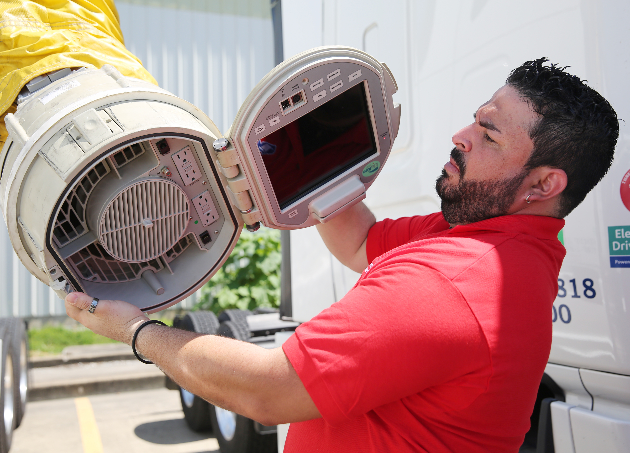 Esteban Torres, master trainer at Covenant Transport, shows off the part of the IdleAir system that is placed into an 18-wheeler cab with a connector to give drivers air-conditioning, heat and power Friday, May 26, 2017, at Covenant Transport in Chattanooga, Tenn. Covenant's IdleAir program recently won a state sustainable transportation award.