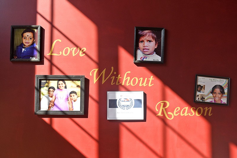 Photos of family and children helped by their charity hang on the wall of Santhosh and Susan Mathew's dining room.  Santhosh and Susan Mathews run a non-profit that pays for medical camps and cleft palate surgeries around the world.