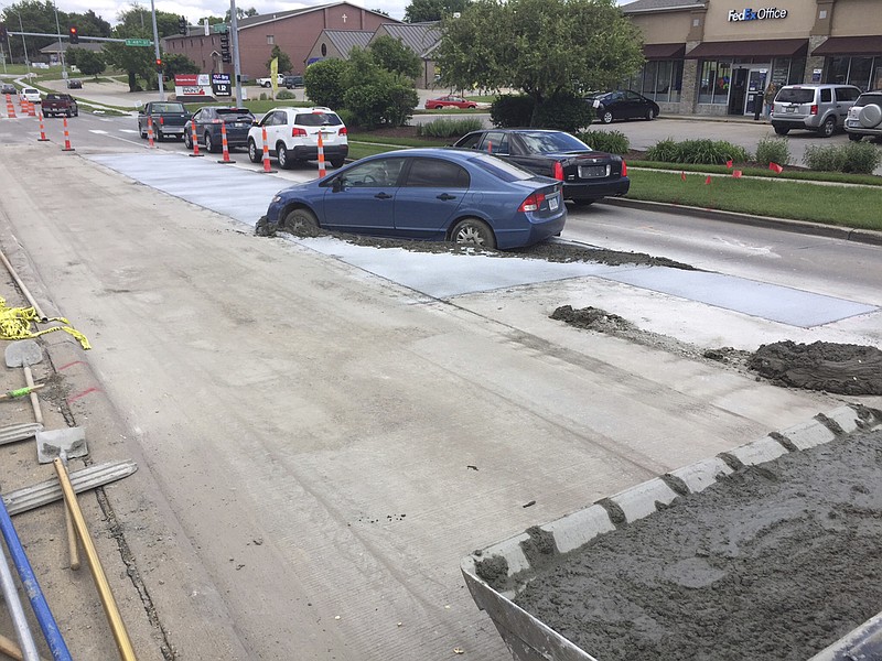 
              In this Wednesday, May 24, 2017 photo, a car driven by a 19-year-old driver is stuck in the newly poured concrete in Lincoln, Neb. A police incident report says it wasn't obvious that the concrete wasn't dry and that driver drove into it through a 24-foot (7-meter) gap between traffic control cones. City engineer Thomas Shafer says the driver is responsible for the repairs and could face about a $10,000 bill for the repairs. (Mike Palm, The City of Lincoln Public Works and Utilities Department via AP)
            