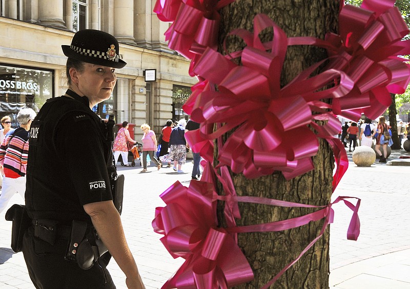 
              Police patrol past a pink ribbon tribute in central Manchester, England Friday May 26 2017. More than 20 people were killed in an explosion following a Ariana Grande concert at the Manchester Arena late Monday evening. (AP Photo/Rui Vieira)
            