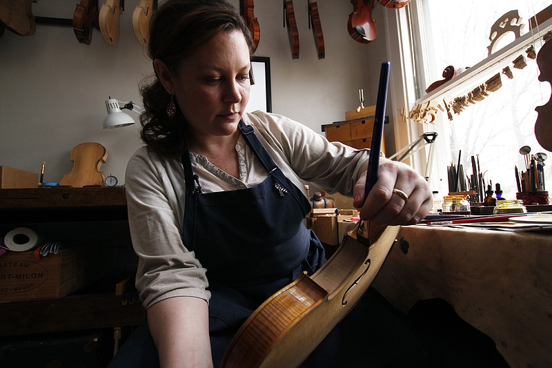 
              Sonja St. John applies varnish on a violin at her workshop in Neenah, Wis., on Thursday, April 27, 2017. Her brother, Jon St. John, died in Iraq in 2007 while serving in the military. Among other things, Sonja has found solace in her career, making and restoring violins. (AP Photo/Carrie Antlfinger)
            