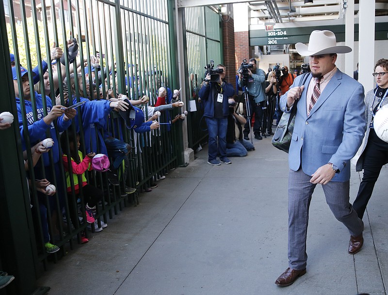 
              Chicago Cubs' Kyle Schwarber departs for the team's road trip wearing a suit based on the character Ron Burgundy in the Anchor Man movie, after a baseball game against the San Francisco Giants Thursday, May 25, 2017, in Chicago. (AP Photo/Charles Rex Arbogast)
            