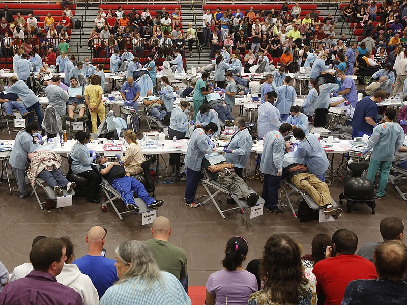 Patients wait on risers as dentists, hygienists and dental students perform procedures in a makeshift dental clinic set up in the Ooltewah High School gymnasium in 2014. (Staff file photo)