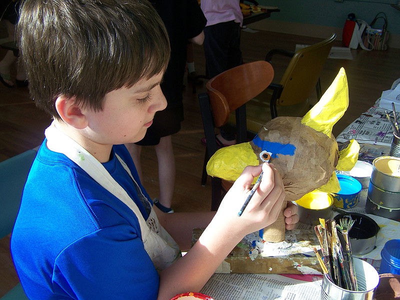 Ben Holcombe, who has attended Puppet Camp since he was a first-grader, adds paint to a puppet. He now works as a counselor and assistant at the camp.