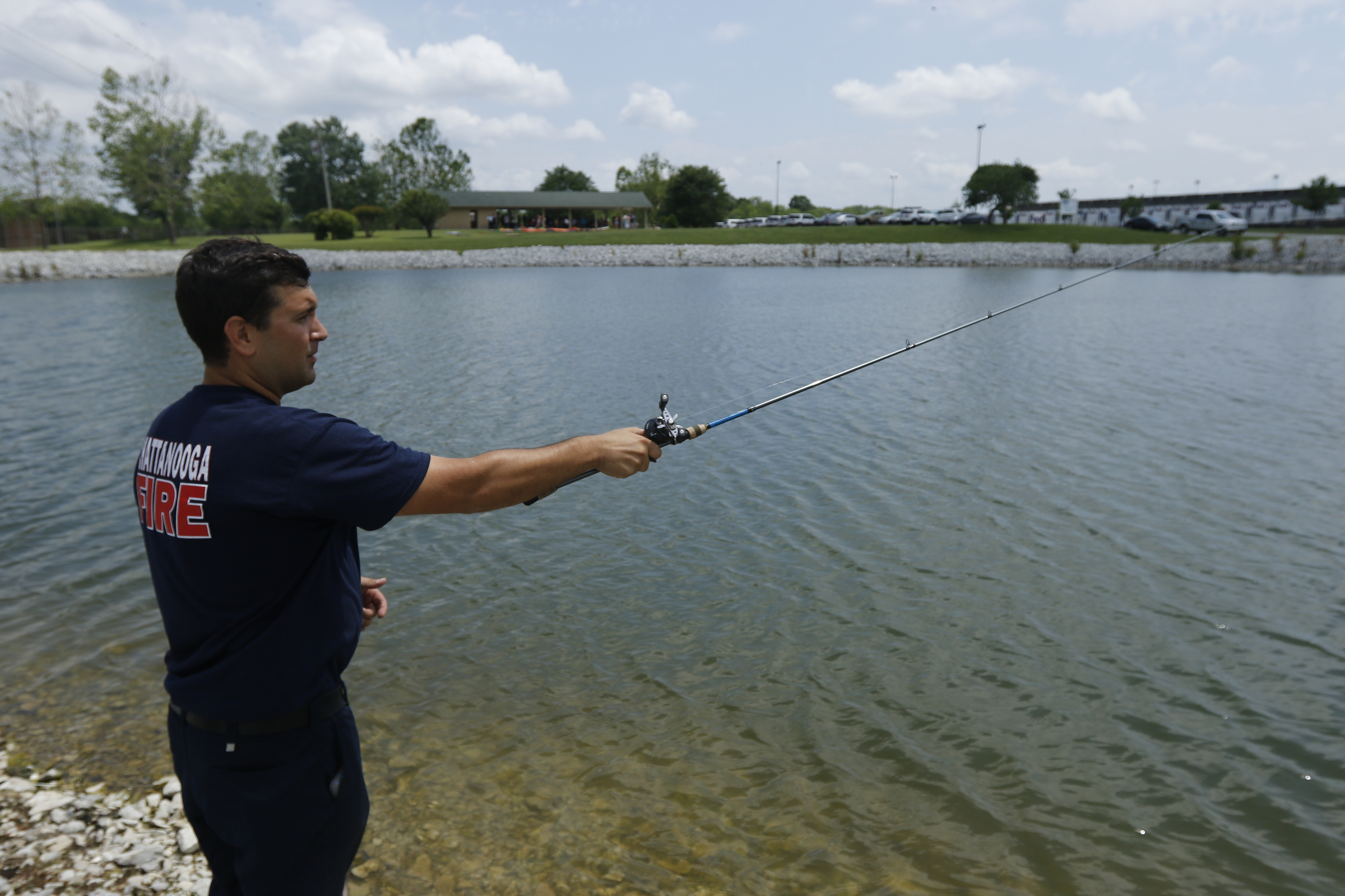 Chattanooga firefighter Brandon Fryar fishes in a pond at the Hamilton County EMS awards ceremony at the Vulcan Materials Plant's picnic area on Saturday, May 27, 2017, in Chattanooga, Tenn.