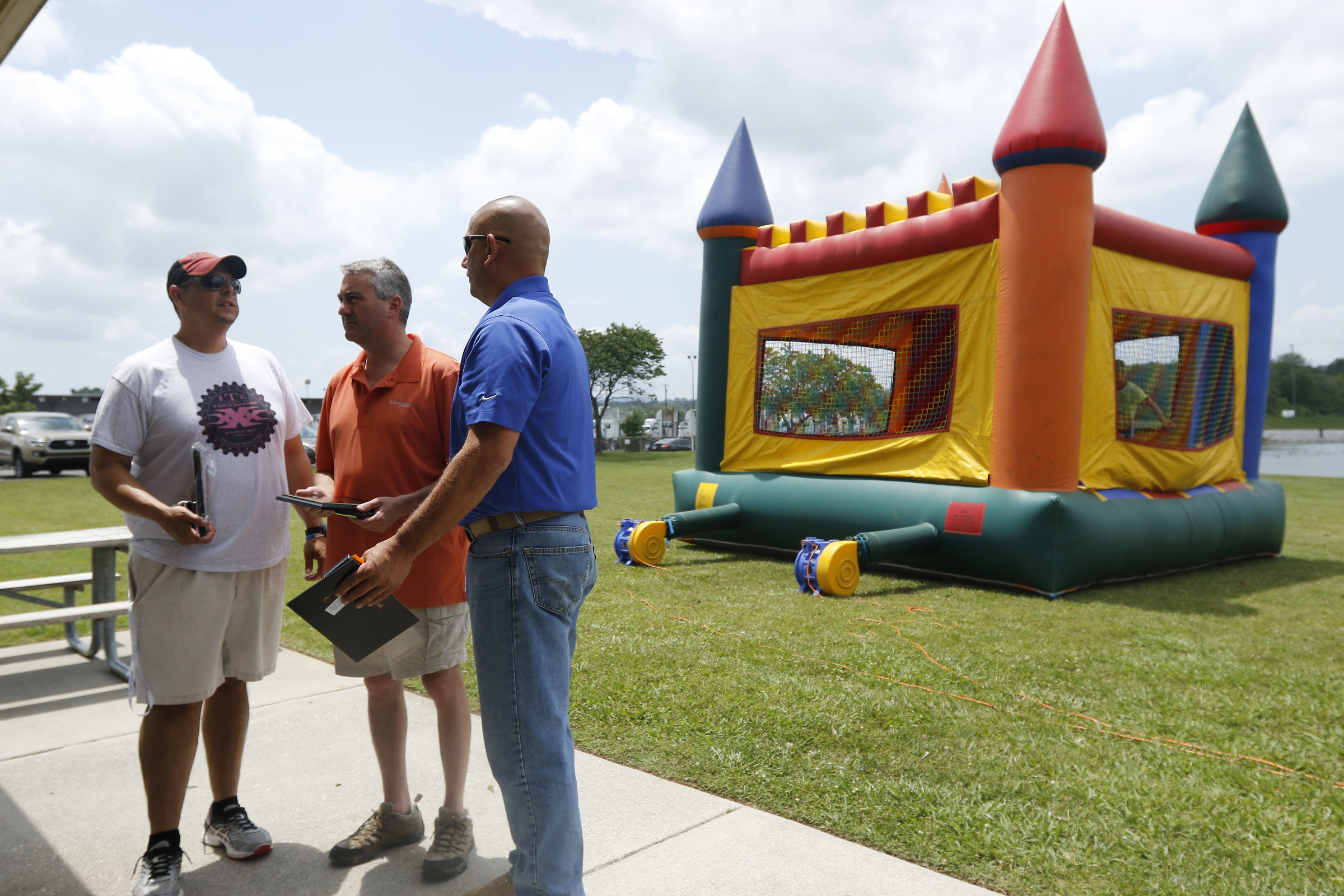 Lt. Billy Blea, left, Tim Hixson, center, and Tony Sylvester, who received awards for trauma call of the year for being among the first to respond to the Woodmore Bus Crash, talk near a bounce castle as others receive the same award at the Hamilton County EMS awards ceremony at the Vulcan Materials Plant's picnic area on Saturday, May 27, 2017, in Chattanooga, Tenn.