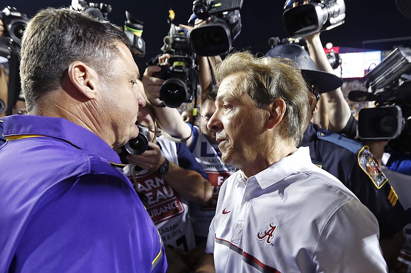 LSU's Ed Orgeron, left, Alabama's Nick Saban, right, and other SEC football coaches are dealing with an earlier signing date and an accelerated recruiting calendar after recent changes to college football rules.