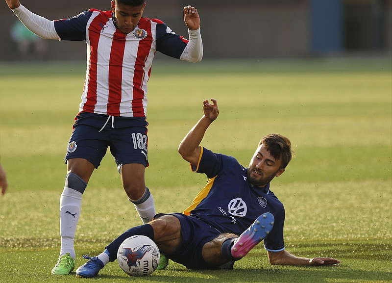 CFC's Kieran Bywater tries to steal the ball as he slides near Chivas's Jonathan Gerardo Martinez Mendoza during Chattanooga FC's exhibition soccer match against Mexican soccer club Chivas U23 at Finley Stadium on Saturday, May 27, 2017, in Chattanooga, Tenn.