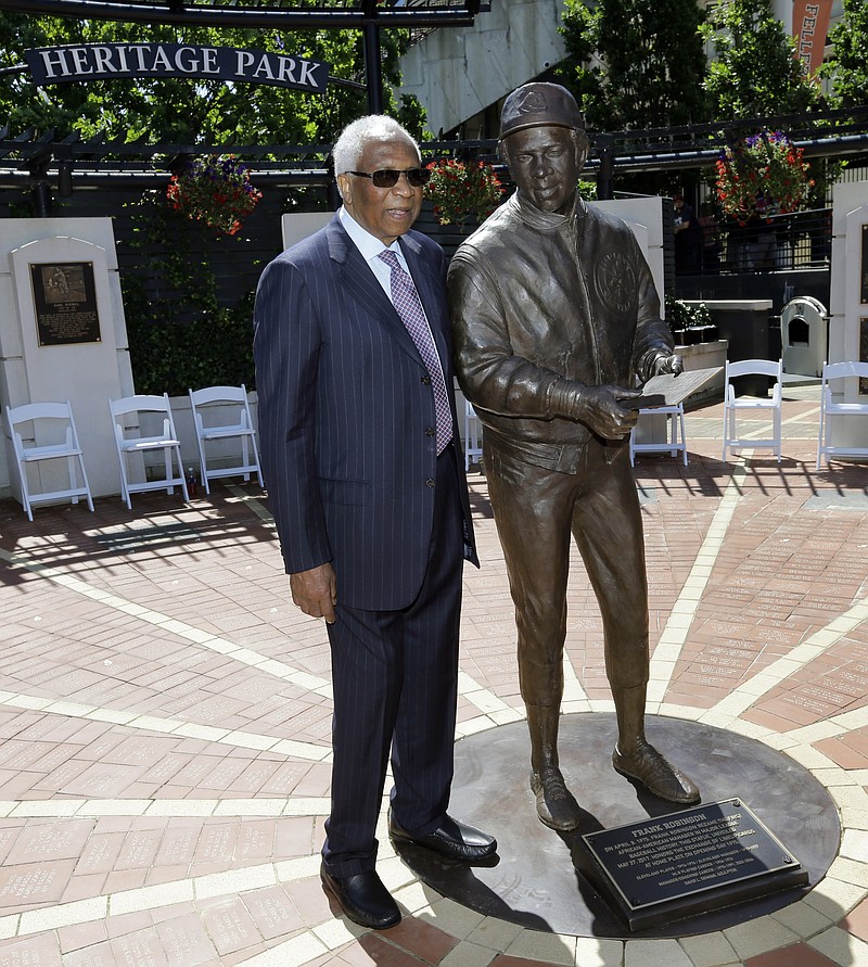 
              Frank Robinson poses with his statue before a baseball game between the Kansas City Royals and the Cleveland Indians, Saturday, May 27, 2017, in Cleveland. Robinson was MLB's first African-American manager. He became a player-manager for the Indians in 1975. (AP Photo/Tony Dejak)
            