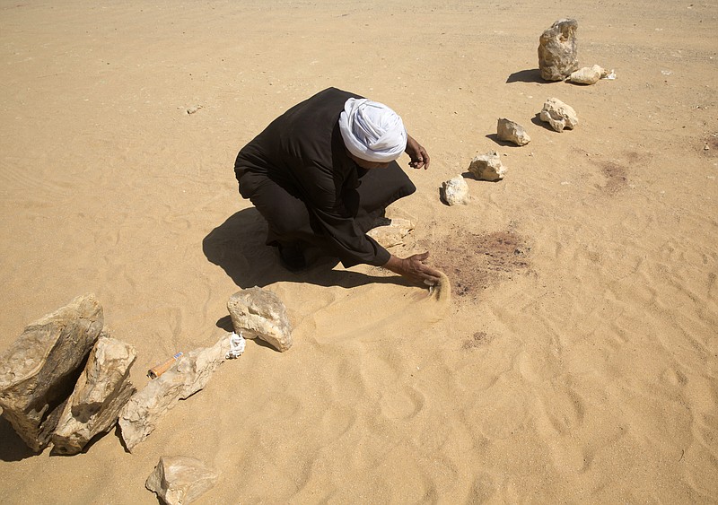 
              A  man covers the blood stains of victims on the road leads to St. Samuel, the Confessor monastery in Maghagha, about 220 kilometers (140 miles) south of Cairo, Egypt, Saturday, May 27, 2017. Masked gunmen ambushed a bus carrying Coptic Christians to a monastery south of Cairo on Friday, killing at least 28 people, and Egypt responded by launching airstrikes against what it said were militant training bases in Libya. (AP Photo/Amr Nabil)
            