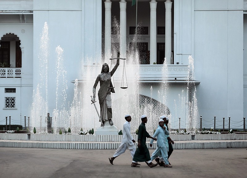 
              FILE - In this Feb. 28, 2017 file photo, Bangladeshi Muslim boys walk past a Lady Justice statue at the Supreme Court complex in Dhaka, Bangladesh. A sculptor says authorities in Bangladesh have reinstalled the Lady Justice statue near the country's Supreme Court, two days after its removal following complaints by Islamist hard-liners. Sculptor Mrinal Haque said Sunday, May 28, 2017 workers put the statue back in place a few hundred meters (yards) from its original location. (AP Photo/A.M. Ahad, File)
            