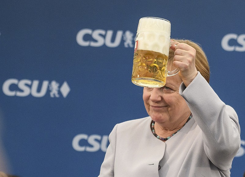 
              German Chancellor Angela Merkel lifts a glass of beer during an election campaign of her Christian Democratic Union, CDU, and the Christian Social Union, CSU, in Munich, southern Germany, Sunday, May 28, 2017. A poll of German voters shows Chancellor Merkel's conservative bloc's lead widening as the main challenger Social Democrats continue to lose support. (Matthias Balk/dpa via AP)
            