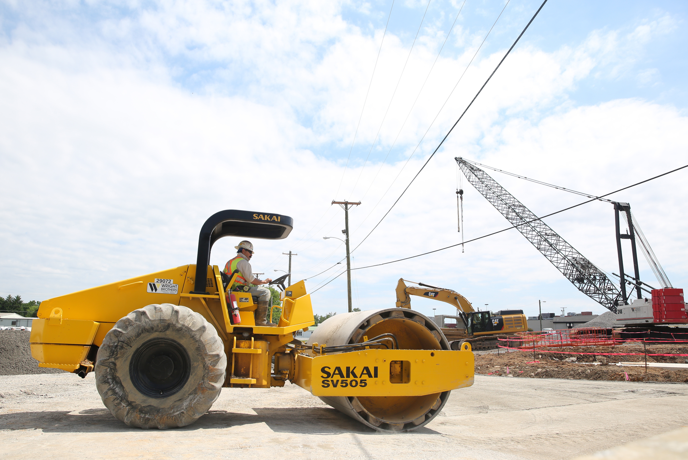 Noe Pina, a heavy equipment operator with Wright Brothers Construction Company, Inc., smooths portions of the road being put back down Friday, May 26, 2017, on St. Elmo Avenue at Broad Street in Chattanooga, Tenn. The intersection upgrade is part of a $17 million multiphase project to overhaul the St. Elmo basinճ drainage network.