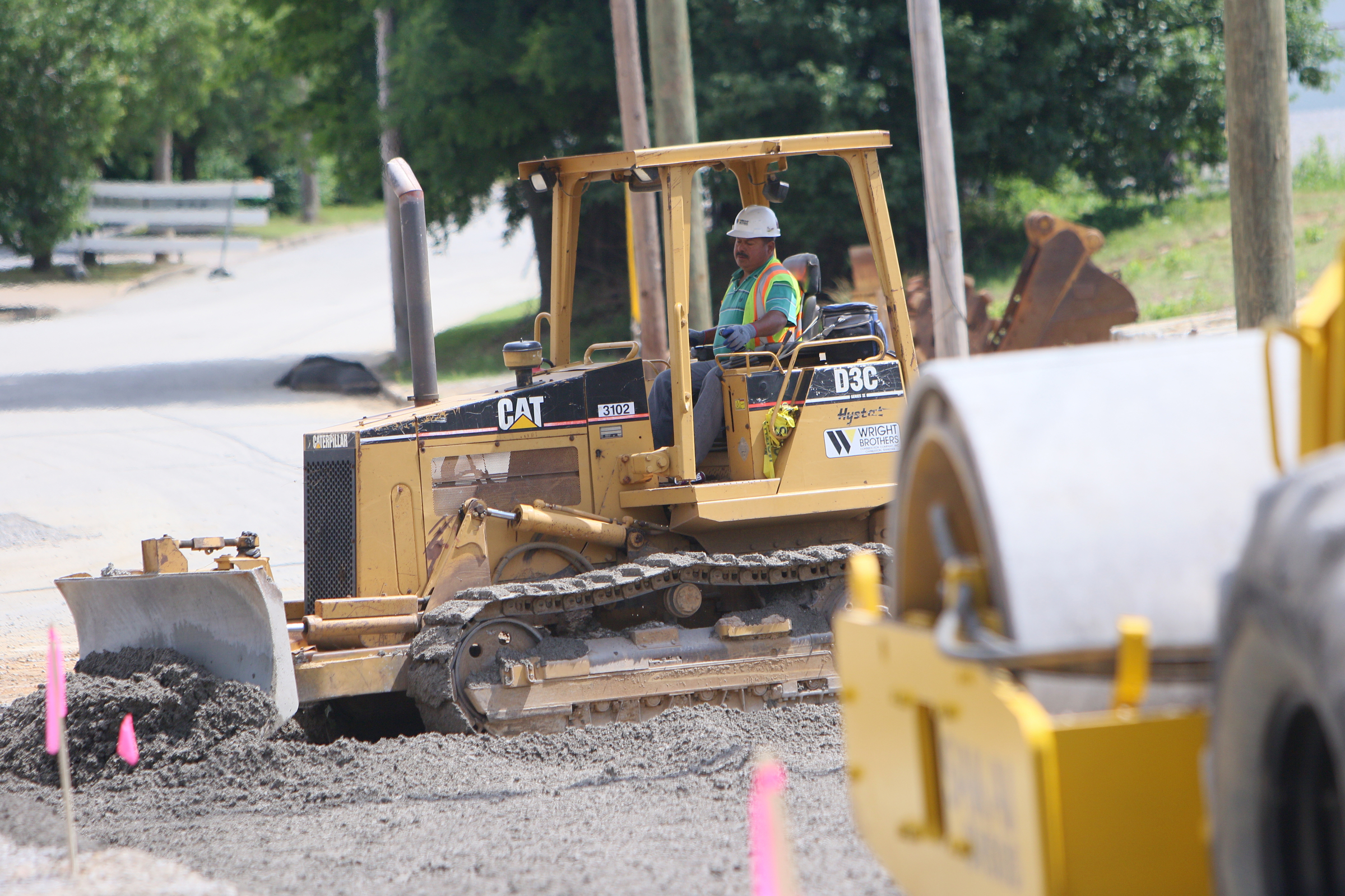 Lucio Hernandez, a heavy equipment operator with Wright Brothers Construction Company, Inc., levels stone as a part of an excavation and drainage project Friday, May 26, 2017, on St. Elmo Avenue at Broad Street in Chattanooga, Tenn. The revamped intersection will have wider pedestrian access and will be incorporated in future Riverwalk extensions.