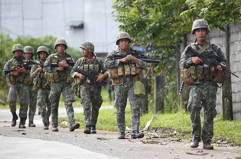 
              Philippine marines walk to the frontline in the continuing assaults to retake control of some areas of Marawi city Sunday, May 28, 2017 in southern Philippines. Philippine forces launched fresh airstrikes Sunday to drive out militants linked to the Islamic State group after days of fighting left corpses in the streets and hundreds of civilians begging for rescue from a besieged southern city. (AP Photo/Bullit Marquez)
            