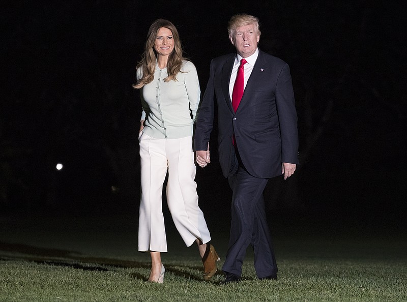
              President Donald Trump and first lady Melania Trump walk from Marine One across the South Lawn to the White House in Washington, Saturday, May 27, 2017, as they return from Sigonella, Italy. (AP Photo/Carolyn Kaster)
            