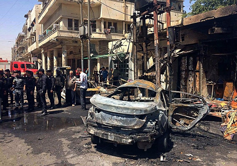 
              Iraqi security forces and civilians inspect the site of a deadly bomb attack, in Baghdad, Iraq, Monday, May 30, 2017. Another bomb exploded outside a popular ice cream shop in the Karrada neighborhood of Baghdad just after midnight on Monday, killing and wounding dozens of civilians, hospital and police officials said. (AP Photo/Karim Kadim)
            