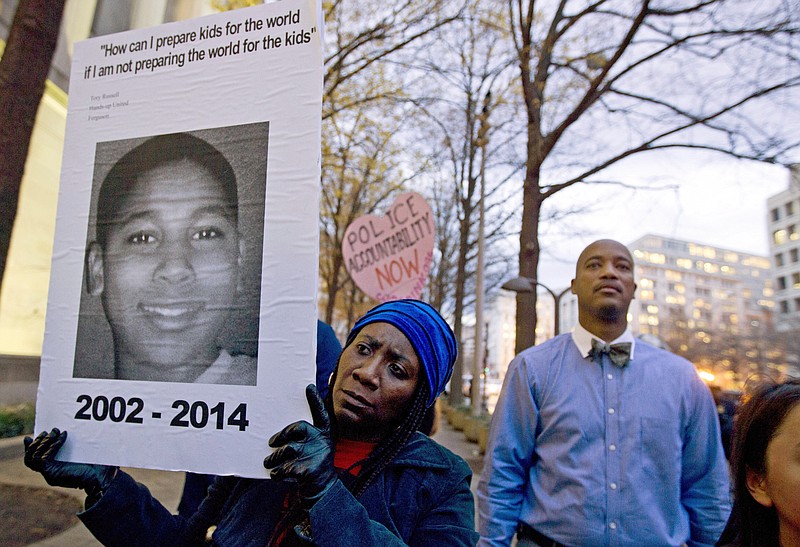 
              FILE – In this Dec. 1, 2014, file photo, Tomiko Shine, left, holds a sign with a photo of Tamir Rice, a boy fatally shot by a Cleveland police officer, while protesting a grand jury's decision in Ferguson, Mo., not to indict police officer Darren Wilson in the shooting death of Michael Brown, during a demonstration in Washington. Cleveland Police Chief Calvin Williams announced Tuesday, May 30, 2017, that Timothy Loehmann, the police officer who shot and killed the 12-year-old boy, has been fired for inaccuracies on his job application, while the officer who drove the patrol car the day of the Nov. 22, 2014, shooting, Frank Garmback, has been suspended for 10 days for violating a tactical rule for his driving that day. (AP Photo/Jose Luis Magana, File)
            