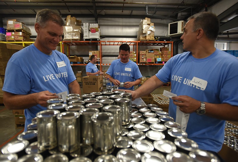 Konrad Heider, Rob Ribaric and Justin Mull, from left, sort cans Thursday, May 26, 2016, at the Chattanooga Area Food Bank. Cigna employees volunteered during their fourth annual Day of Caring.