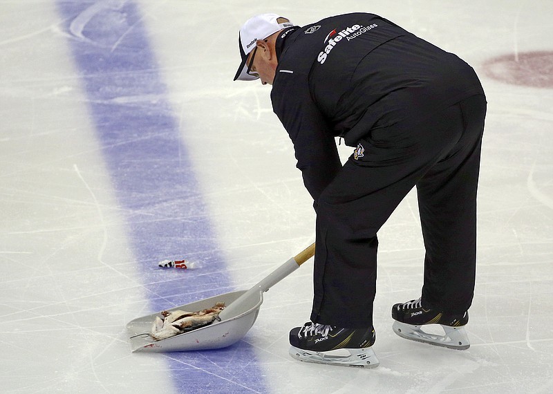 An ice worker removes a fish during the second period of Game 1 of the NHL hockey Stanley Cup Finals between the Pittsburgh Penguins and Nashville Predators on Monday, May 29, 2017, at PPG Paints Arena in Pittsburgh. Authorities said Jacob Waddell, of Nolensville, Tenn., is facing charges after allegedly throwing a dead catfish onto the ice during the hockey game, including misdemeanor counts of possessing instruments of crime and disrupting meetings or processions, as well as a summary count of disorderly conduct. The Tennessee Bureau of Investigation commented on social media that investigators had never seen an "instrument of crime" like that. (AP Photo/Gene J. Puskar)