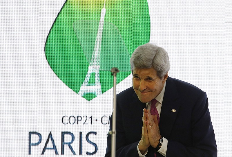 Then-U.S. Secretary of State John Kerry bows during a 2015 news conference held while negotiations leading up to the Paris Climate Agreement were taking place.