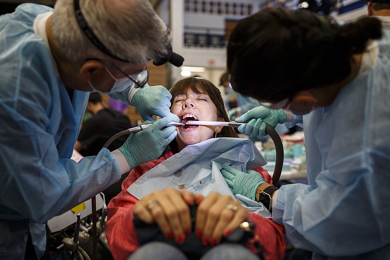 Capt. Coleman Palmertree, left, and LCDR Amy Alvis, right, work on Stephanie Beliveau's teeth during a Remote Area Medical treatment day at Red Bank High School on Saturday, June 3, 2017, in Chattanooga, Tenn. Remote Area Medical provides mobile medical clinics which deliver free care to underserved communities.