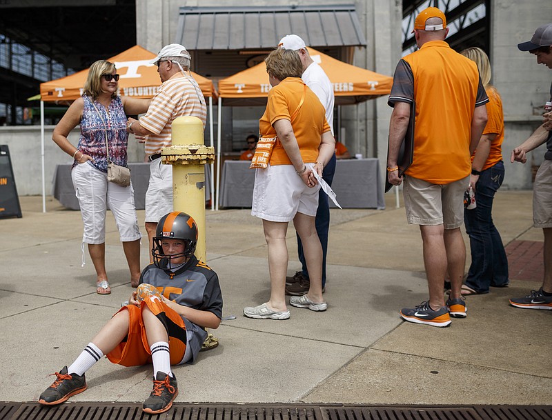 Sam Mann sits near a line to enter the Big Orange Caravan's stop at the First Tennessee Pavilion on Saturday, June 3, 2017, in Chattanooga, Tenn. The event gave fans the chance to meet Tennessee Athletics coaches and new athletic director John Currie.