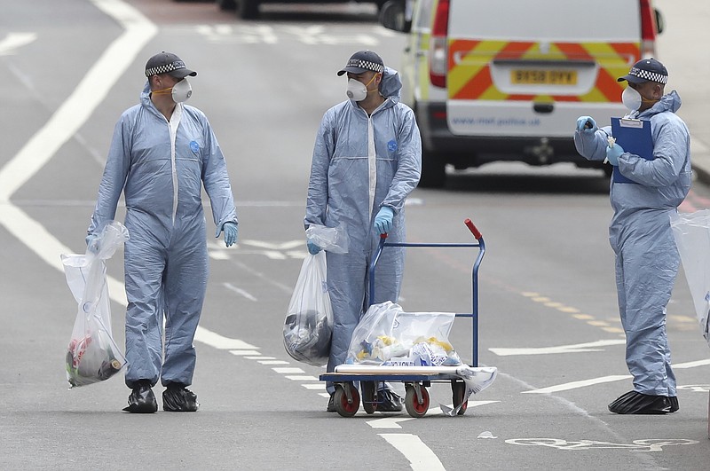 Police forensic officers on London Bridge Sunday June 4, 2017 following Saturday night's terrorist incident. The assault began Saturday night when a van veered off the road and barreled into pedestrians on busy London Bridge. Three men fled the van with large knives and attacked people at bars and restaurants in nearby Borough Market, police and witnesses said. The attack unfolded quickly, and police said officers had shot and killed the three attackers within eight minutes. (Andrew Matthews/PA via AP)