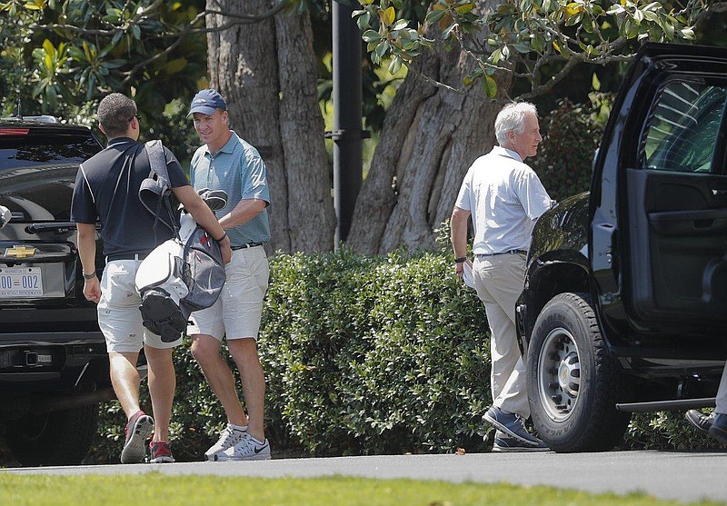 Peyton Manning (center left) and Tenn. Sen. Bob Corker (right) are pictured exiting President Donald Trump's motorcade returning from Trump National Golf CLub in Sterling, Va. 
(PABLO MARTINEZ MONSIVAIS/AP)
